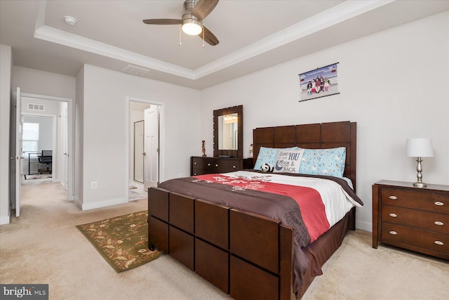 bedroom featuring visible vents, light colored carpet, a raised ceiling, and baseboards