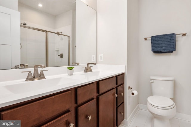 bathroom with baseboards, toilet, double vanity, a stall shower, and a sink