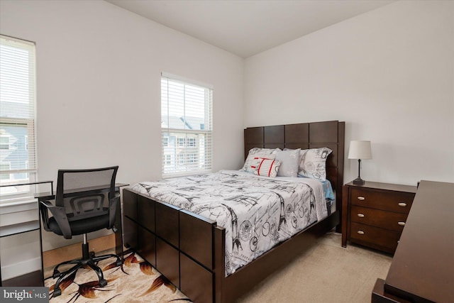 bedroom with baseboards and light carpet