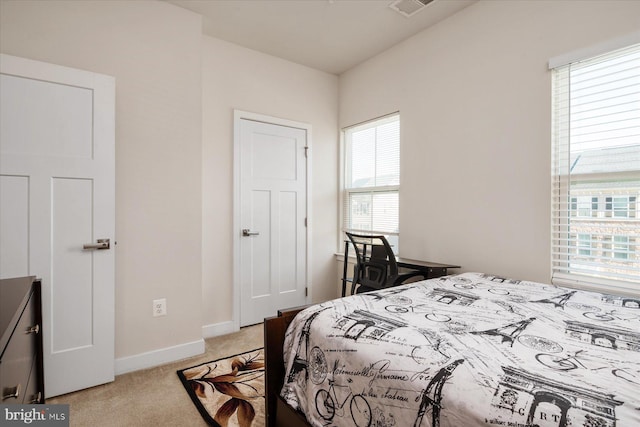 bedroom featuring visible vents, light colored carpet, and baseboards