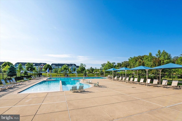 pool with a patio and fence