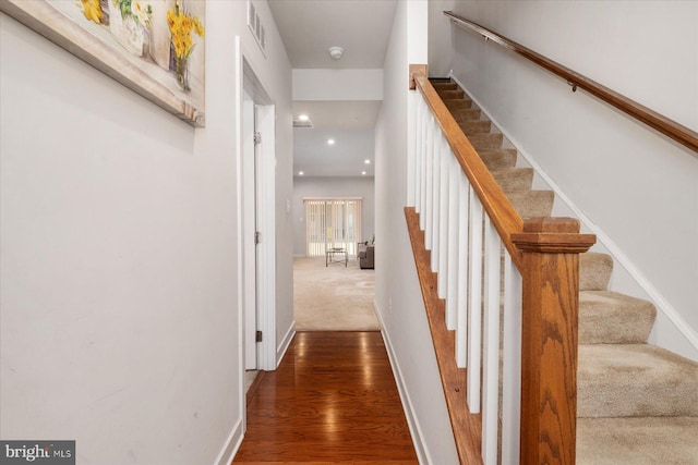 hallway with visible vents, stairs, baseboards, and wood finished floors