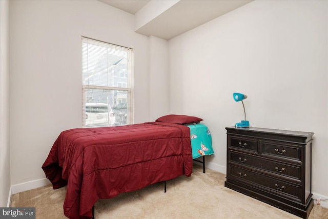 bedroom with baseboards and light colored carpet