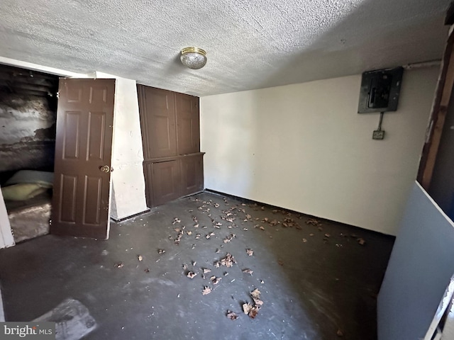 unfurnished bedroom with electric panel and a textured ceiling