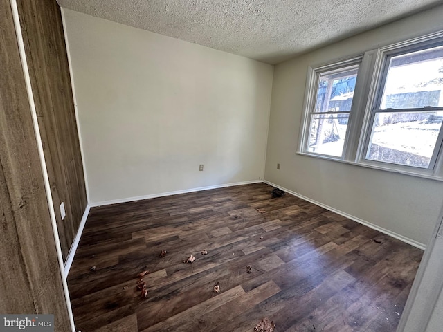 unfurnished bedroom with dark wood-style floors, baseboards, and a textured ceiling