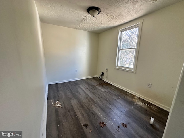 interior space featuring baseboards, dark wood finished floors, and a textured ceiling