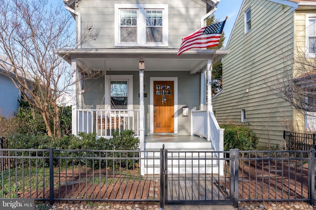 view of front of house featuring covered porch, a fenced front yard, and a gate