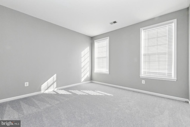 carpeted spare room with baseboards and visible vents