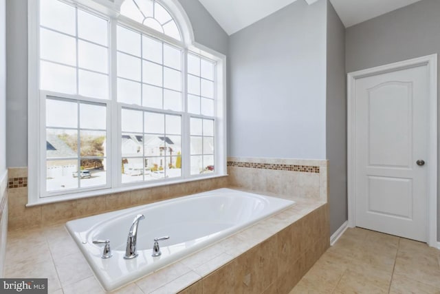 full bath with a garden tub, vaulted ceiling, and tile patterned floors