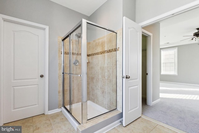 bathroom featuring ceiling fan, baseboards, a shower stall, and tile patterned floors