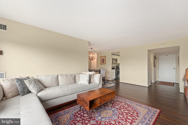 living area with a chandelier and dark wood finished floors