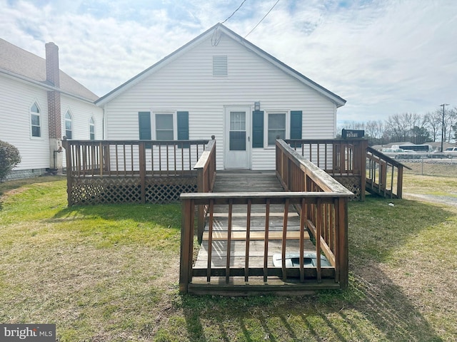 rear view of house featuring a lawn and a wooden deck