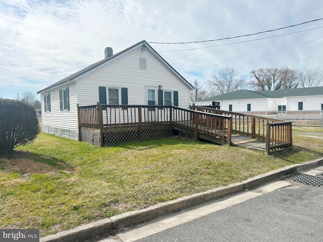 view of front facade with a deck and a front lawn