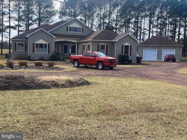 view of front of property featuring a detached garage, a front lawn, and an outbuilding