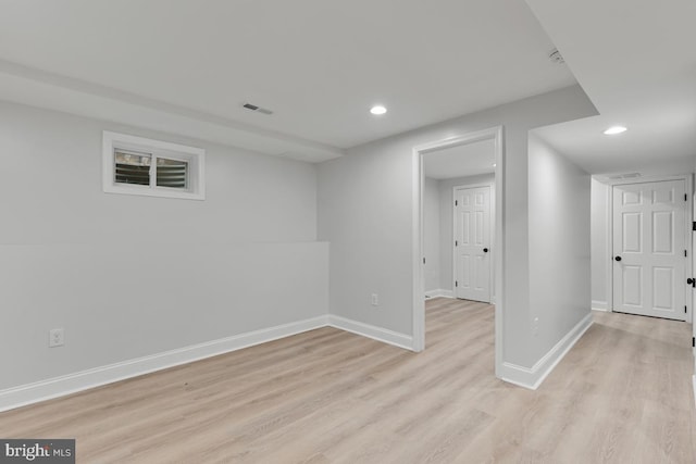 finished below grade area with visible vents, recessed lighting, light wood-style flooring, and baseboards