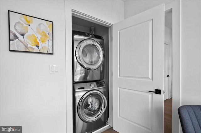 washroom featuring stacked washer / dryer and laundry area