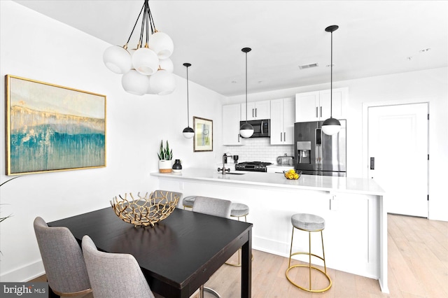 dining space featuring visible vents and light wood finished floors