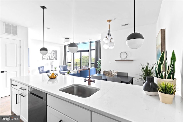 kitchen with white cabinets, visible vents, a sink, and stainless steel dishwasher