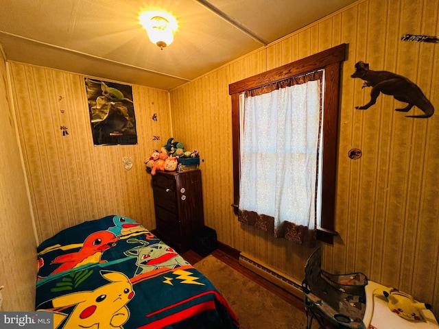 bedroom featuring wooden walls and baseboard heating