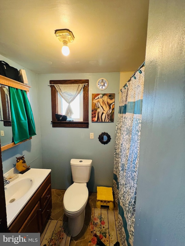 bathroom with toilet, curtained shower, and vanity