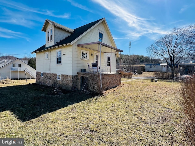 view of side of property with a porch and a lawn