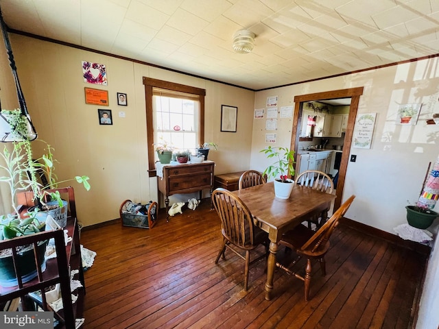 dining space with ornamental molding, wood-type flooring, and baseboards