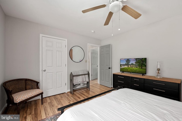 bedroom featuring baseboards, light wood-style flooring, and a ceiling fan