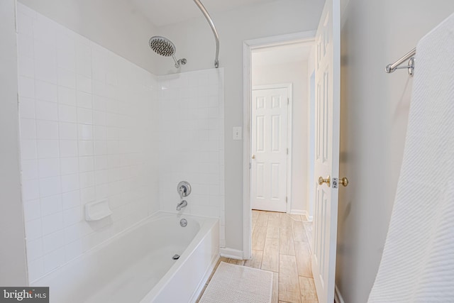 bathroom featuring  shower combination, baseboards, and wood finished floors