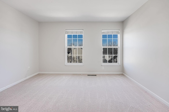 unfurnished room with carpet floors, baseboards, and visible vents