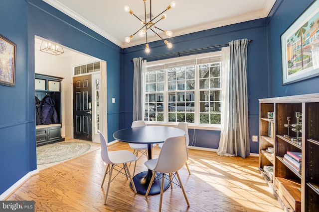 dining area with crown molding, baseboards, a notable chandelier, and wood finished floors