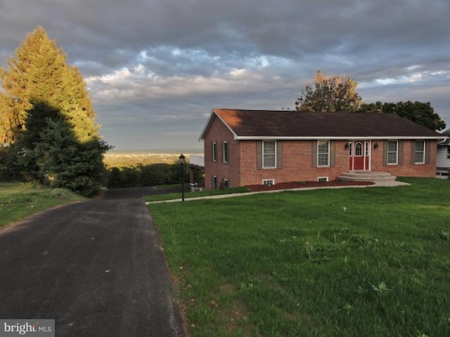 ranch-style house featuring brick siding and a front lawn