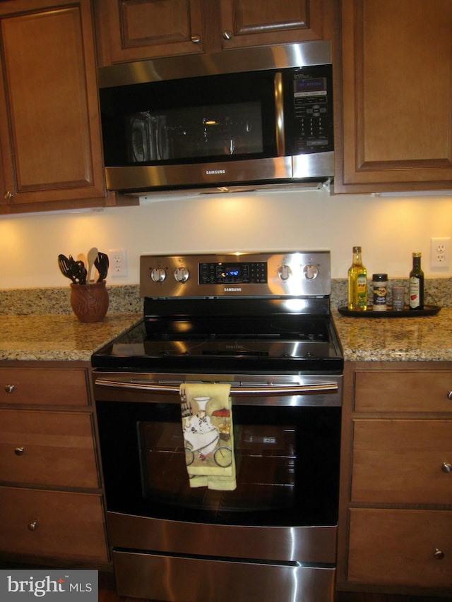 kitchen with stainless steel appliances and light stone countertops