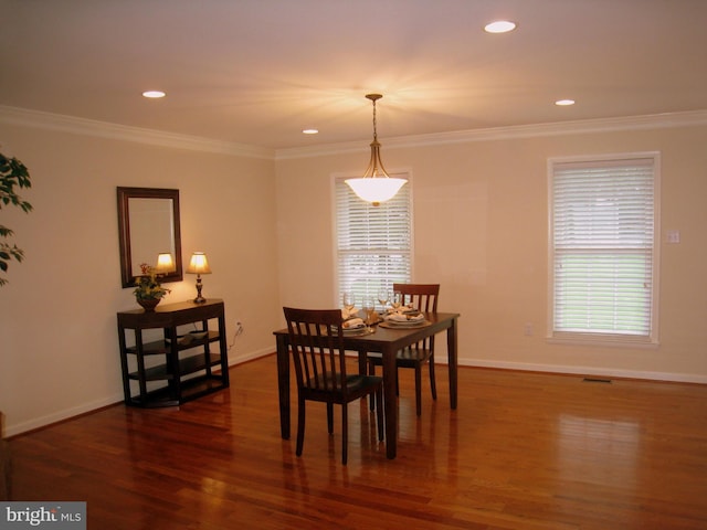 dining area with ornamental molding, dark wood finished floors, and baseboards