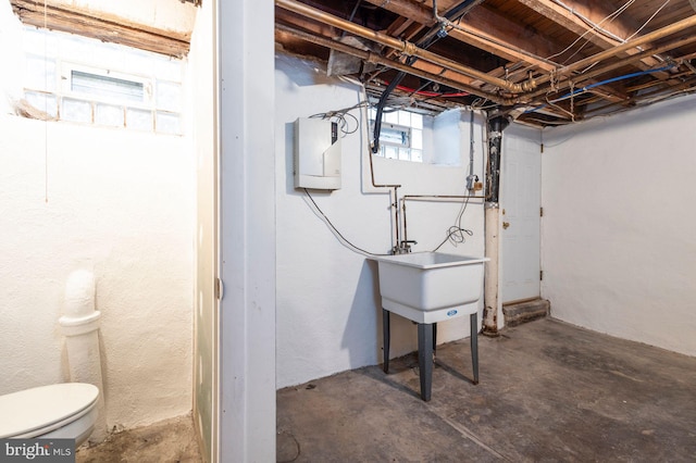 below grade area with electric panel and a sink