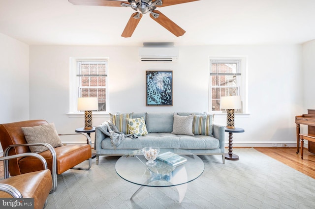 living area featuring ceiling fan, baseboards, wood finished floors, and a wall mounted AC