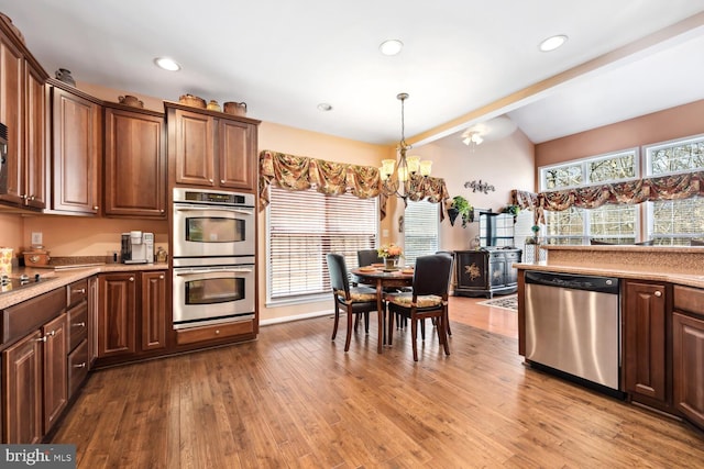 kitchen with stainless steel appliances, a chandelier, plenty of natural light, and wood finished floors