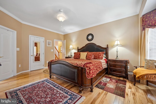 bedroom featuring hardwood / wood-style flooring, baseboards, and ornamental molding