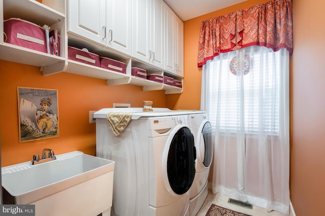 laundry area featuring cabinet space, visible vents, a sink, and independent washer and dryer