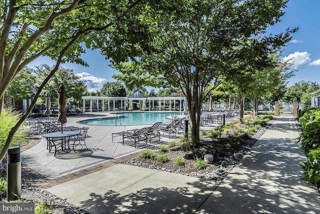 pool with a patio, fence, and a pergola