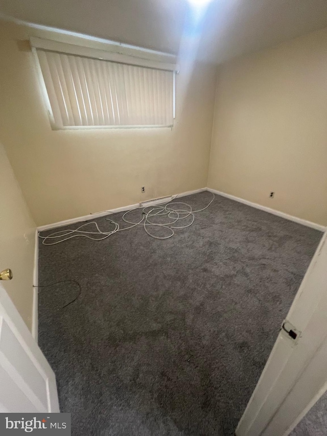 unfurnished room with baseboards and carpet