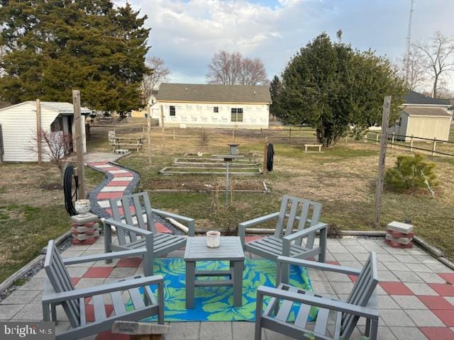 view of yard featuring a patio area, fence, and an outdoor structure