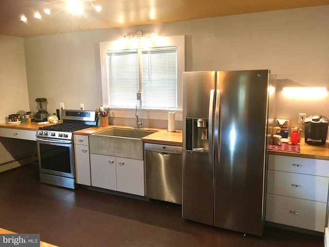 kitchen with stainless steel appliances, white cabinets, and a sink