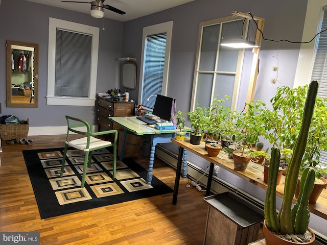 office space featuring a ceiling fan, baseboards, and wood finished floors