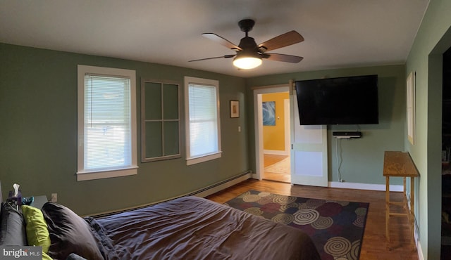 bedroom with ceiling fan, baseboards, and wood finished floors