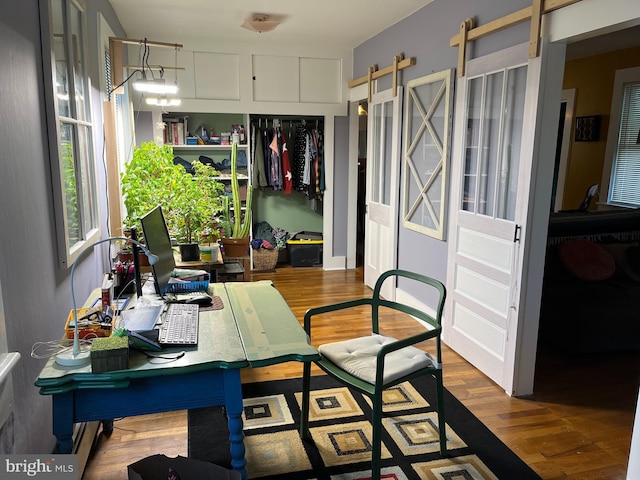 dining room featuring a barn door and wood finished floors