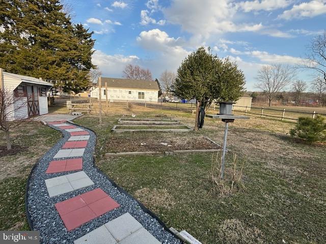 view of yard with fence, an outdoor structure, and a storage shed