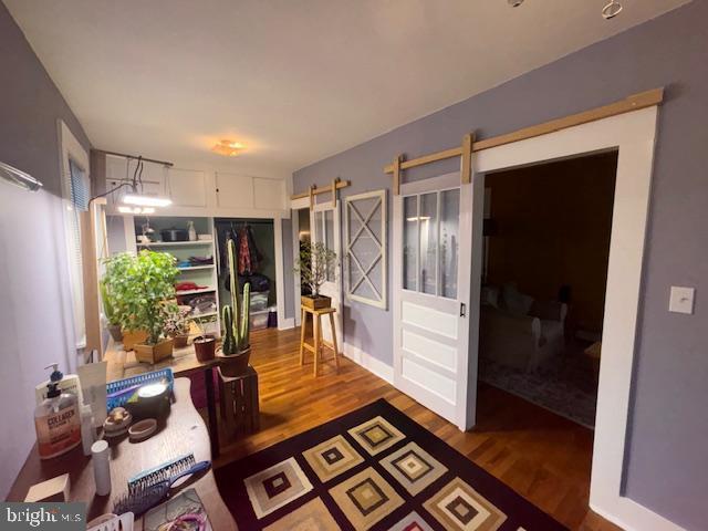 interior space with a barn door and wood finished floors