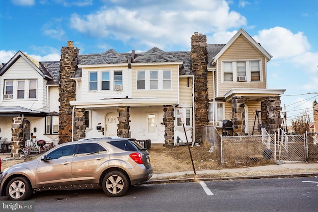 view of property featuring a gate, a chimney, fence, and a high end roof