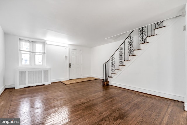 entryway featuring stairs, radiator heating unit, and wood-type flooring