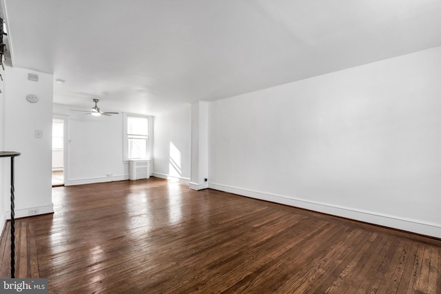 unfurnished living room featuring dark wood finished floors, baseboards, and ceiling fan